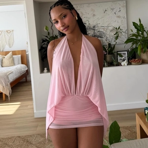 Detail of pink mesh halter dress featuring a deep V-neck and ruched backless design