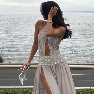 Detail of waist shell sequins and high slit on a light gray halter maxi dress
