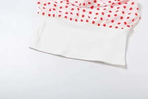 Detail of red polka dot fabric with white elastic waistband on a summer crop top