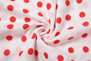 Detailed macro view of high-quality red polka dot fabric with smooth texture and drape