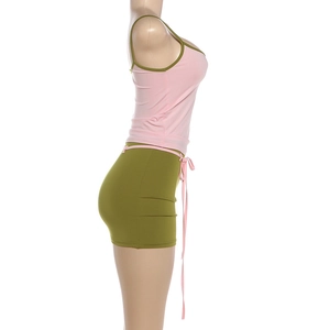 Détail du haut rose et du short vert avec des bordures contrastées et un cordon de serrage