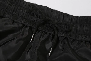 Detail view of high elastic waistband with black drawstring and silver metal tips