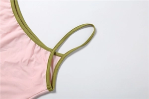 Détail du tissu en maille rose avec bretelles vert olive sur un débardeur ajusté