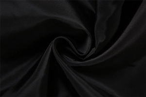 Detailed macro view of the black twill fabric texture and soft pleated polyester material