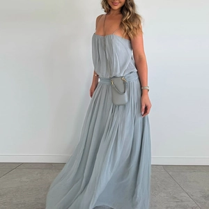 Detail showing the pleated waist and flowing light blue-grey chiffon slit dress