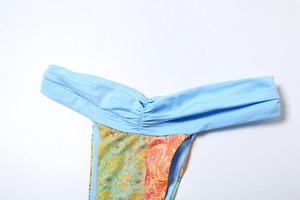 Macro shot of V-cut high-waisted bikini bottoms with blue ruching and vibrant geometric prints