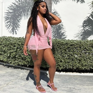 Detail of light pink deep V-neck ruched mini dress showing the cross-halter neck design