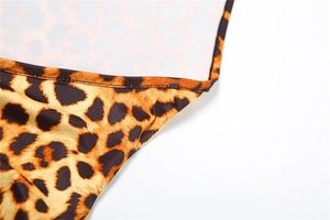 Dettaglio ravvicinato del tessuto leopardato con cuciture di qualità sulla tutina