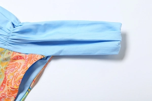Detail of light blue smocked elastic strap and orange geometric print fabric seams