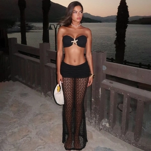 Detail of black strapless bikini top with a gold starfish charm and lace beach cover-up