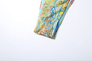 Close-up detail of high-elasticity fabric with vibrant abstract paisley pattern and texture