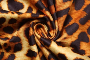 Dettaglio macro del tessuto con stampa leopardata, trama a maglia morbida e pieghe fini