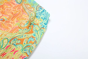 Macro detail of colorful paisley print fabric with vibrant orange and blue patterns
