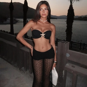 Detail shot of a black strapless crop top featuring a golden starfish buckle on lace set