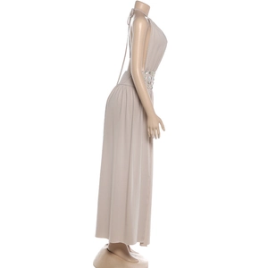 Detail of waist cut-out with circular disc accent on beige halter neck maxi dress