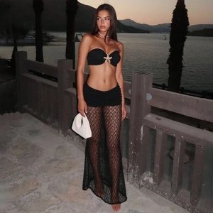 Detail of black lace maxi skirt and tube top with starfish charm at beach sunset