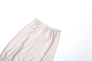 Detailed view of the beige high-waisted elastic waistband on a soft fabric dress
