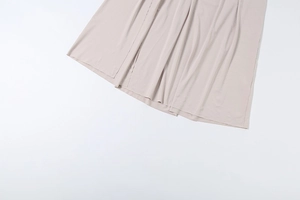 Detail view of champagne satin fabric with elegant drape and smooth texture on dress hem