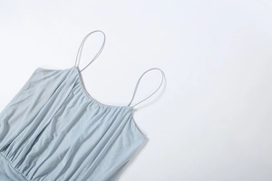 Detailed view of light blue camisole neckline featuring delicate pleats and thin straps
