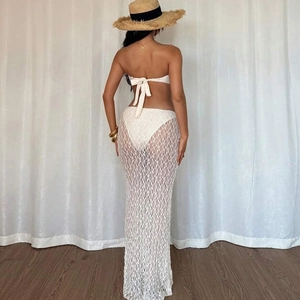 Detail of white crochet lace maxi skirt with floral hollow pattern for summer beach wear