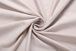 Close-up of champagne knit fabric folded into a rose showing soft silk texture