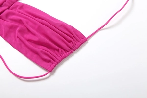 Detail of rose pink mesh fabric with ruching and adjustable drawstrings on a mini dress