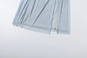 Detail of light blue mesh fabric with sheer texture and side slit design on dress