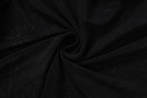 Macro detail of soft black sheer mesh fabric texture with subtle folds and drape
