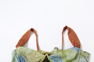 Detail of artistic watercolor print top with unique pleated straps and auburn cord accents