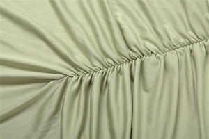 Detailed view of the elegant ruched seam on a sage green slim fit bandeau dress
