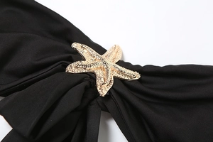 Detail of a golden starfish metal buckle on a black lace strapless long dress set