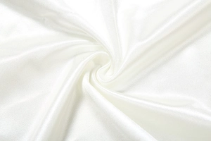 Macro shot showing the glossy white satin fabric texture and silky sheen of the dress