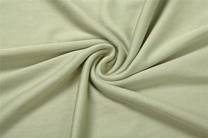 Close-up of light green knitted fabric texture with spiral drape detail
