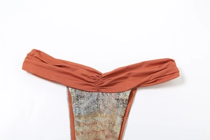 Detail of contrasting bikini bottom with rust red gathered waist and abstract print