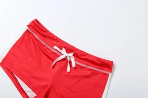 Close-up of red and white contrast shorts featuring elastic waistband and drawstrings