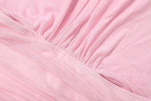 Detailed macro view of the light pink semi-transparent mesh fabric with fine gathering