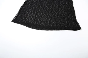 Close-up of the intricate black floral lace pattern and curved hem on the summer dress