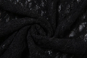 Macro shot of delicate black lace fabric with intricate floral patterns and mesh texture