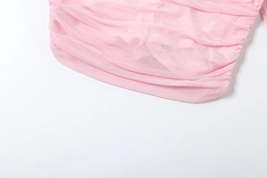 Detail of pink ruched mesh fabric showing semi-transparent texture and pleated design