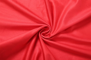 Detailed view of vibrant red textile fabric with soft folds and elegant smooth texture