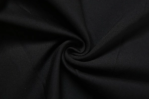 Gros plan sur la texture du tissu en maille noire montrant l'élasticité et la finition lisse