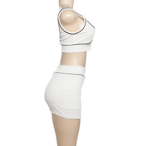 Seitenansicht des weißen zweiteiligen Crop-Tops und Shorts mit schwarzen Kontrastpaspeln