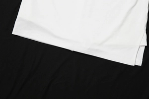 Detailansicht von weißem Rippstrickstoff mit Seitenschlitz und feinen Doppelsteppnähten