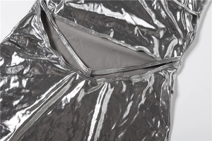 Macro detail of silver metallic dress featuring liquid mirror texture and cutout design