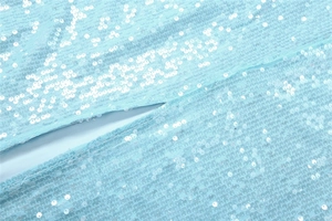 Detailed view of light blue sequin fabric with silver glitters and fine stitching detail