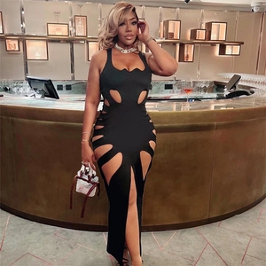 Détail d'une robe longue noire ajourée en maille avec décolleté plongeant et fente
