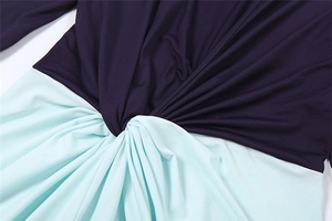 Detail of deep purple and mint green knit dress with twist knot waist design