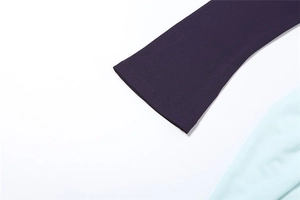 Detail of knit fabric sleeve hem with fine double-needle stitching in purple and mint
