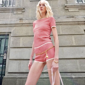 Vue détaillée de l'ensemble en tricot à carreaux rouge et blanc avec haut et short ajusté