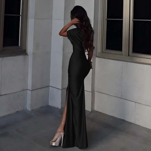 Détail de la robe longue noire moulante avec fente haute et texture satinée élégante